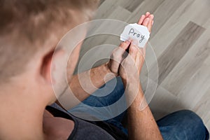 Piece Of Paper With Text Pray In Man`s Hand