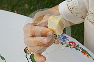 A piece of parmesan cheese in the hand of an old woman