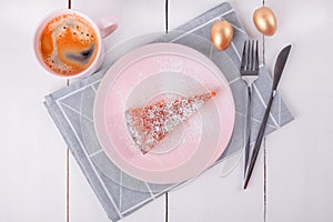 A piece of pie on a pink plate with a knife and fork on a folded linen napkin