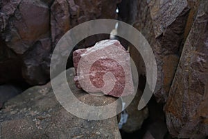 Piece of Pink Arkose Sandstone rock on nature background. Sandstones are sedimentary rocks.