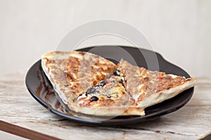Piece of pizza on black plate