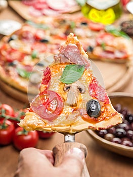 Piece of pizza with mushrooms, ham and tomatoes.