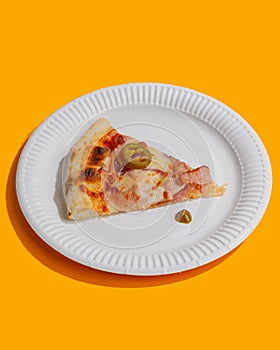 A piece of pizza is on a white paper plate. yellow background