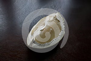 A piece of pomelo fruit on a dark kitchen table