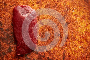 Piece of raw fresh beef steak placed on rusty background