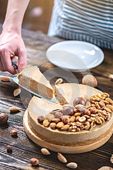 Piece of raw nutty cake on a blue wooden background. Healthy fresh summer vegan dessert. Gluten free and sugar free food