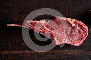 Piece of raw rack of lamb on a dark wooden background. View from above. BBQ cooking. Meat ingredients