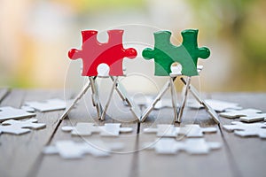 Piece of Red and green  jigsaw puzzle On the old wood And green background. teamwork concept.  symbol of association and