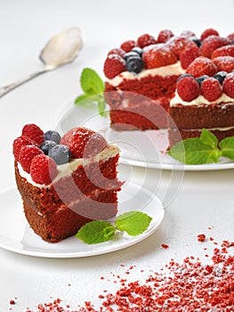 Piece of red velvet cake on plate, studio shot