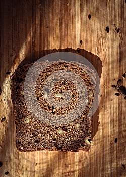 A piece of rye bread on a wooden board