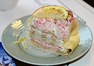 A piece of sandwich cake with salmon and shrimp
