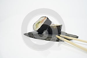 a piece of shushi with chopsticks in white background