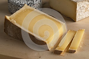 Piece of sliced French Abondance cheese on a cutting board close up