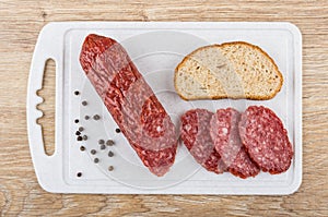 Piece of smoked sausage and slices on cutting board