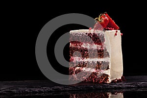 Piece of strawberry cake on a black background.