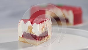 A piece of strawberry cake on a white plate. Rotates counterclockwise.