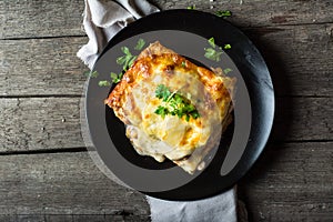 Piece of tasty hot lasagna with red wine. Small depth of field. Traditional italian lasagna. Portion. Italian food. Food on black