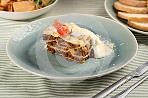 Piece of tasty hot lasagna served on a blue plate. Italian cuisine concept. meat lasagna with creamy sauce.