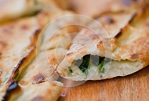 Piece of tasty Pide, turkish homemade pizza with cheese, spinach and herbs