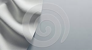 A piece of textured fabric spread out on a light gray, smooth surface, slightly folded to create soft shadows