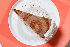 A piece of tiramisu topping with cocoa powder