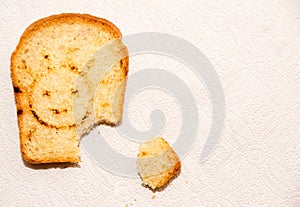 A piece of toast bread on a paper towel with smiling sun.