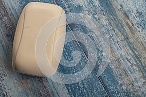 A piece of toilet soap on a wooden background. Frequent hand washing with soap is a prevention of COVID-19 infection. Close up