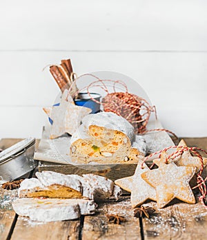 Piece of Traditional German Christmas cake Stollen with festive cookies