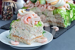 Piece of traditional savory swedish sandwich cake Smorgastorta w
