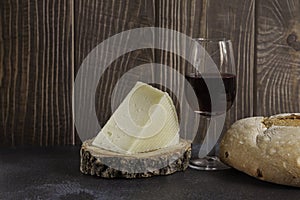 Piece of typical spanish manchego cheese on wood slice