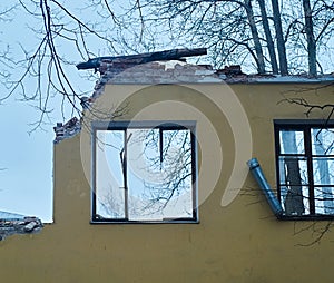 Piece of the wall of ruined house with broken windows, dismantling of building