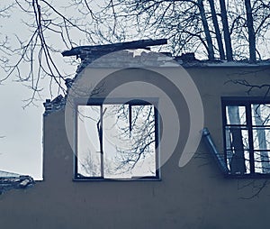 Piece of the wall of ruined house with broken windows, dismantling of building