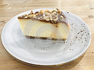 A piece of walnut cheesecake on a round plate.