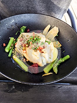 Piece of white fish, served with asparagus, beets, bacon and chives.