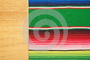 Piece of wood on colorful serape. Empty template for text