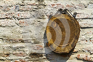 Piece of wood hanging on old brick wall, space for text