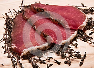 Pieces of beef on a wooden surface with thyme