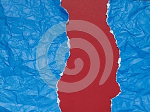 Pieces of blue paper torn and crumpled on a red background