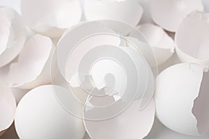 Pieces of broken eggshells on white background, closeup