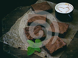 Pieces of cake chocolate brownies on wooden background.