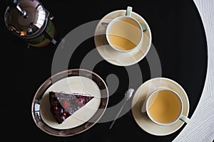 Pieces of cake. Drink hot chocolate cocoa coffee in cups. Black background.