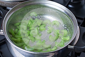 Pieces of celery in boiling water on the stove