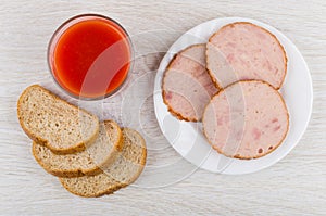 Pieces of chicken sausage, bread, glass of tomato juice