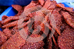 Pieces of chili covered mango snacks at a market