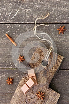 Pieces of chocolate, cinnamon sticks and star anise on a wooden board, photo rusticstyle