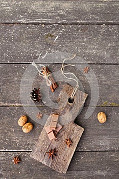 Pieces of chocolate, cinnamon sticks and star anise on a wooden board, photo rusticstyle