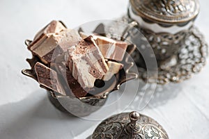 Pieces of chocolate Oriental halva with coffee in a Cup. Eastern tea party
