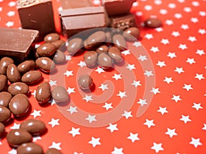 Pieces of chocolates on red background