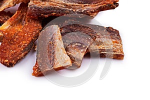 Pieces of cleaned dried fish isolated on white. Dry Peppered Pollack. Amber with pepper