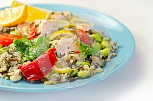 Pieces of cooked salmon and edamame soya beans with red pepper  and baby leaf spinach, served with brown long grain rice with